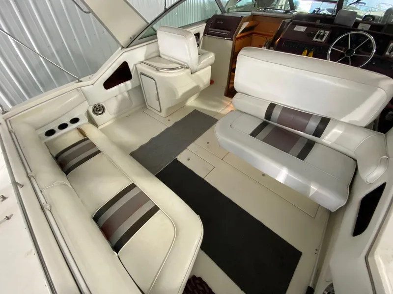 Slide: The Image of 1990 Sea Ray Sundancer boat interior with white and striped seating. - 9