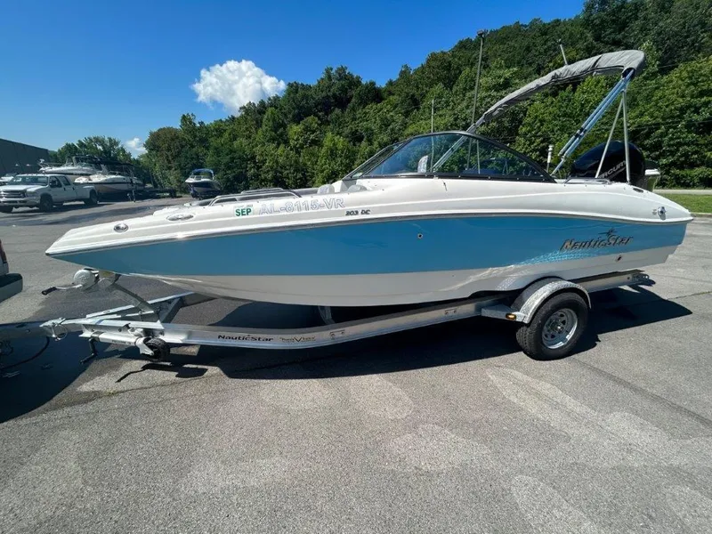 Slide: The Image of 2022 NauticStar 203DC Sport Deck boat on trailer, parked outdoors. - 2