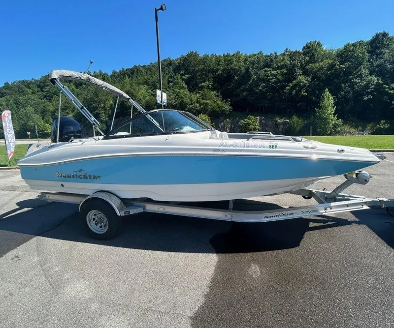 The Image of 2022 NauticStar 203DC Sport Deck boat on trailer, parked outdoors. - 1