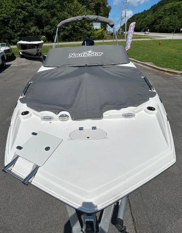 Slide: The Image of 2022 NauticStar 203DC Sport Deck boat with cover, parked on a trailer. - 3