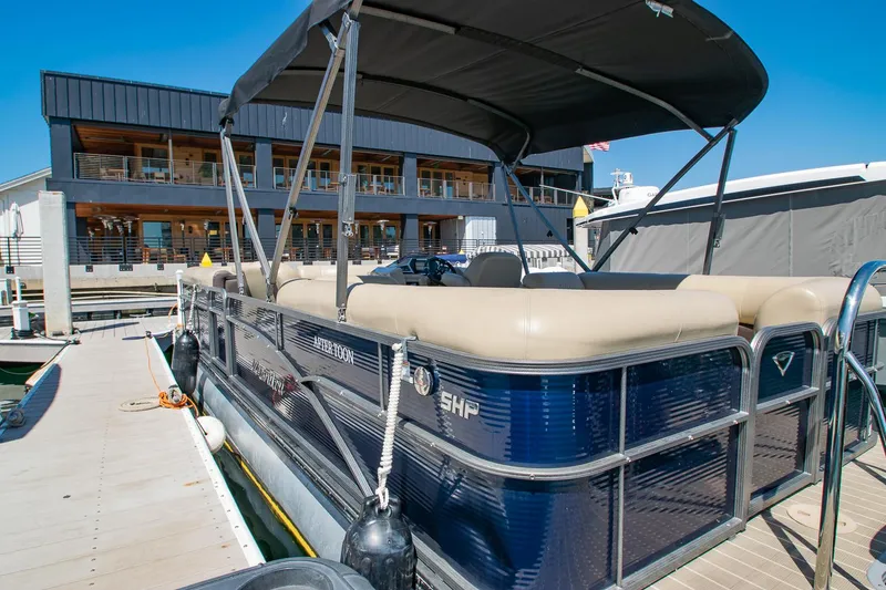 Slide: The Image of 2021 Manitou Oasis SHP pontoon boat docked, featuring a sleek design and spacious seating. - 34