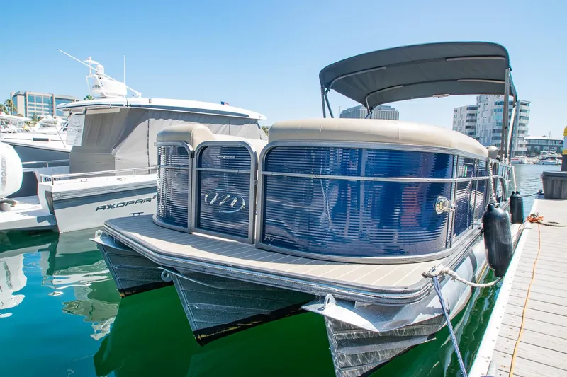 Slide: The Image of 2021 Manitou Oasis SHP pontoon boat docked in a marina under clear blue skies. - 35