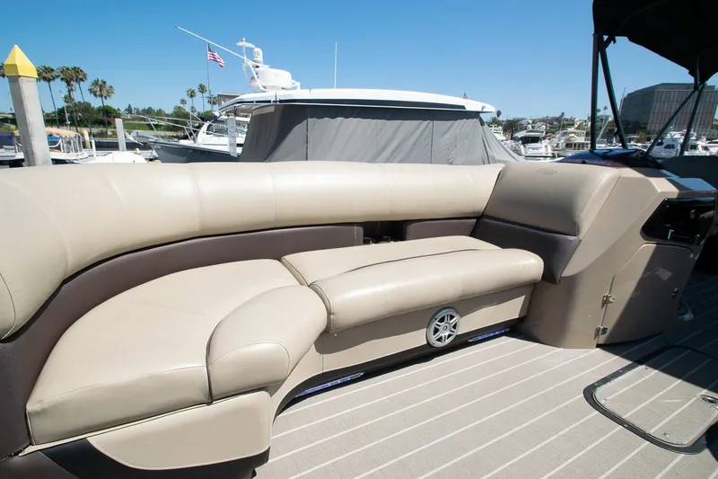 Slide: The Image of 2021 Manitou Oasis SHP pontoon boat with beige seating at a marina. - 41