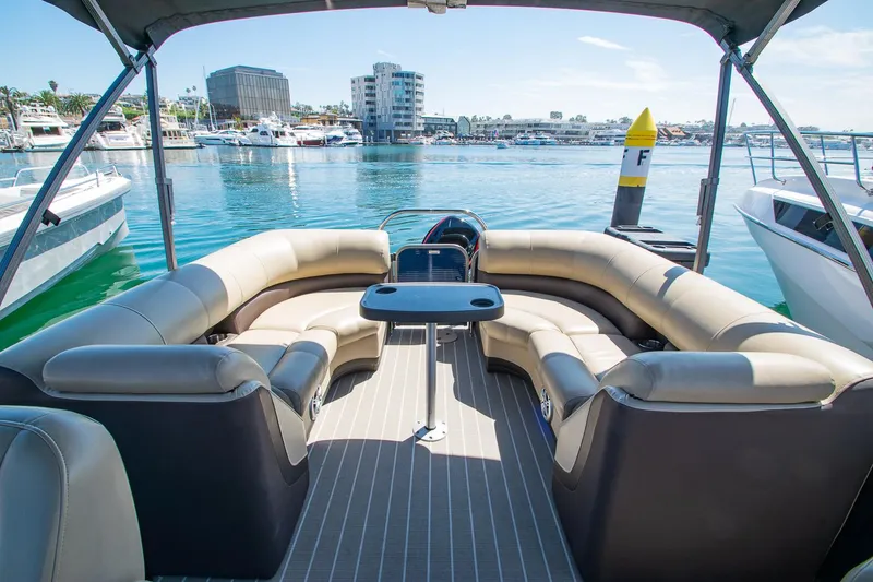 Slide: The Image of 2021 Manitou Oasis SHP pontoon boat with spacious seating, docked in a marina. - 43