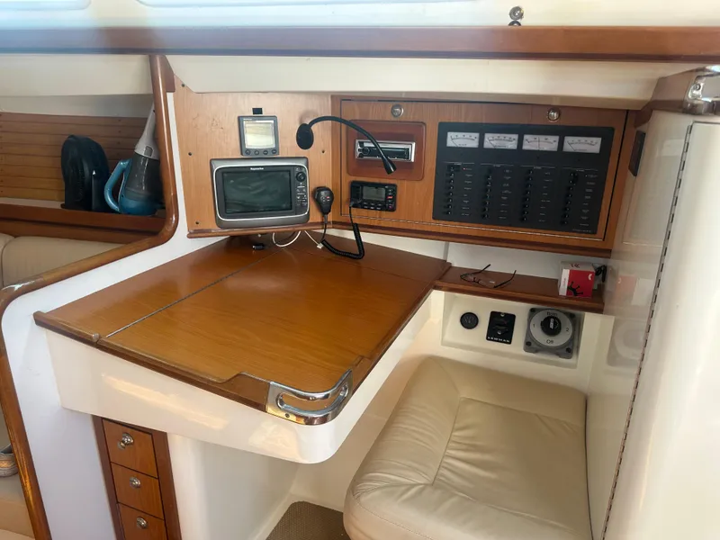 Slide: The Image of Navigation station with wood surface, electronics, and seating inside a boat. - 14