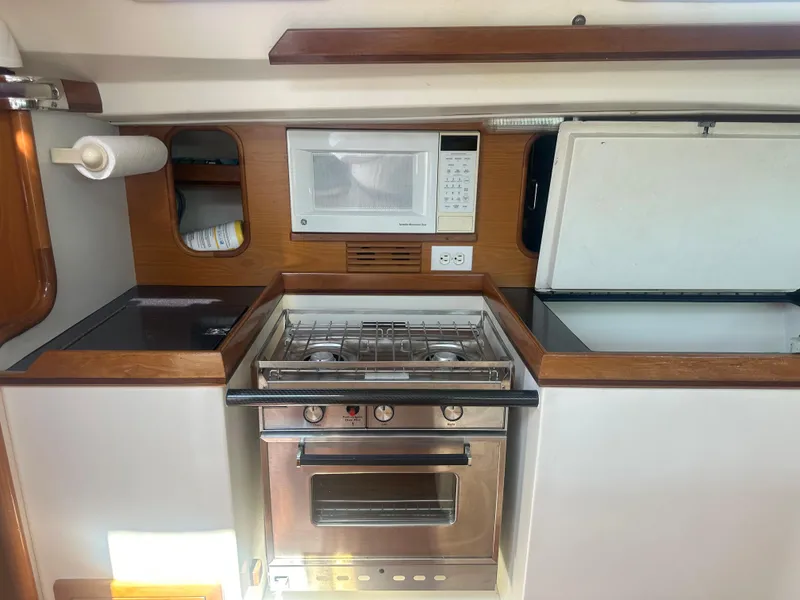 Slide: The Image of Interior view of a boat kitchen with stove, microwave, and refrigerator. - 18