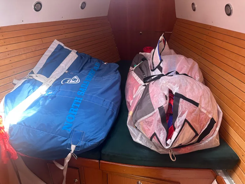 Slide: The Image of Two sail bags rest on a green mattress in a wooden cabin. - 11