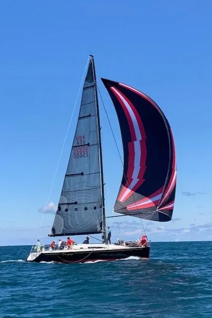 Slide: The Image of A 2001 Farr Concordia sailboat with a colorful spinnaker sails on open water. - 45