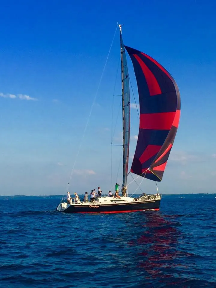Slide: The Image of Sailboat with colorful sail on calm water. - 28