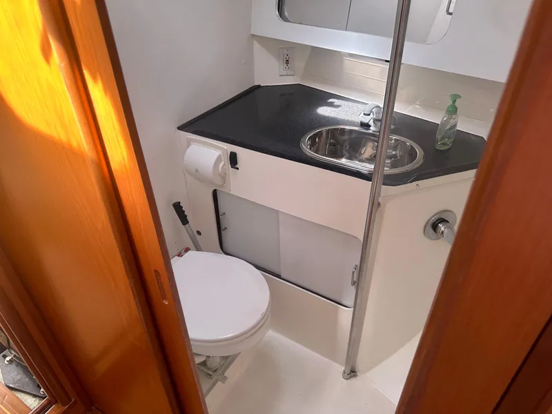 Slide: The Image of The image shows a boat bathroom with a sink, toilet, and mirror. - 9