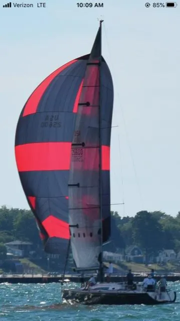 Slide: The Image of A 2001 Farr Concordia sailing with a red and black spinnaker on the water. - 35