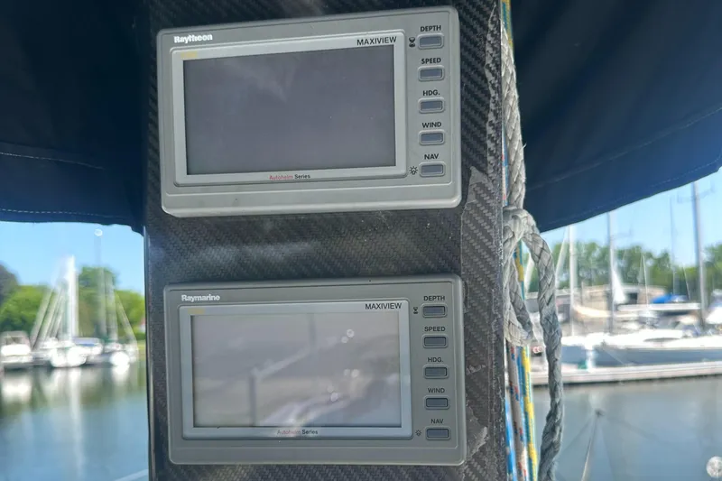 Slide: The Image of Two Raytheon marine displays on a boat mast, surrounded by ropes, with a marina in the background. - 40