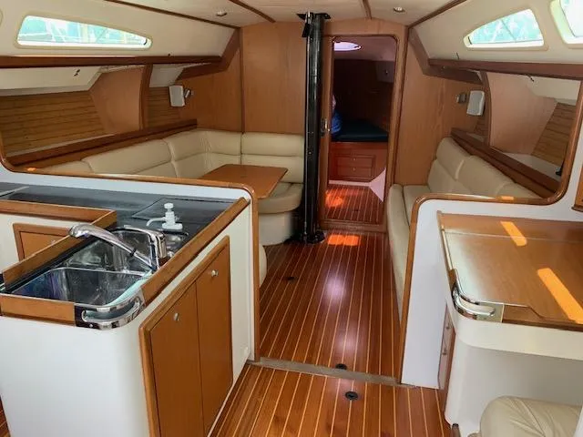 Slide: The Image of Interior of a 2001 Farr Concordia with wood flooring and cream-colored upholstery. - 31