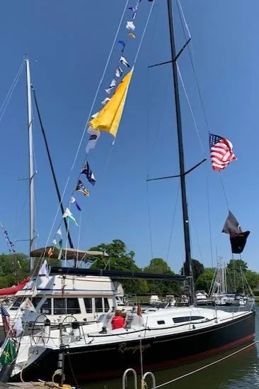 Slide: The Image of A 2001 Farr Concordia with colorful flags, docked in a harbor. - 42