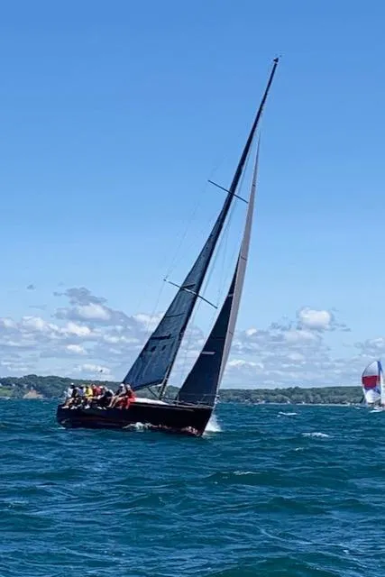 Slide: The Image of A sleek sailboat glides on blue water under a clear sky. - 43
