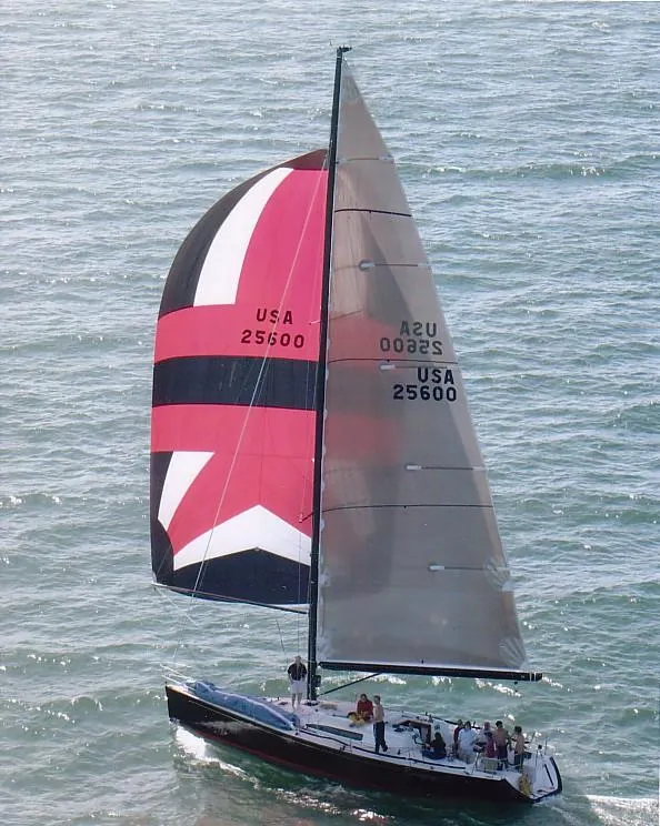 Slide: The Image of A 2001 Farr Concordia sailing with a striking black, red, and white sail on the water. - 29