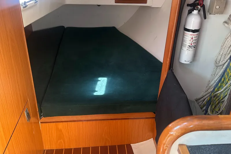 Slide: The Image of Interior of a 2001 Farr Concordia with a green bed and fire extinguisher. - 44