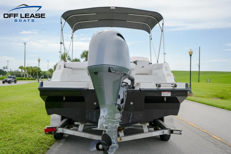 Slide: The Image of 2022 Starcraft SVX 231 OB boat on trailer, rear view with outboard motor, Off Lease Boats logo. - 13