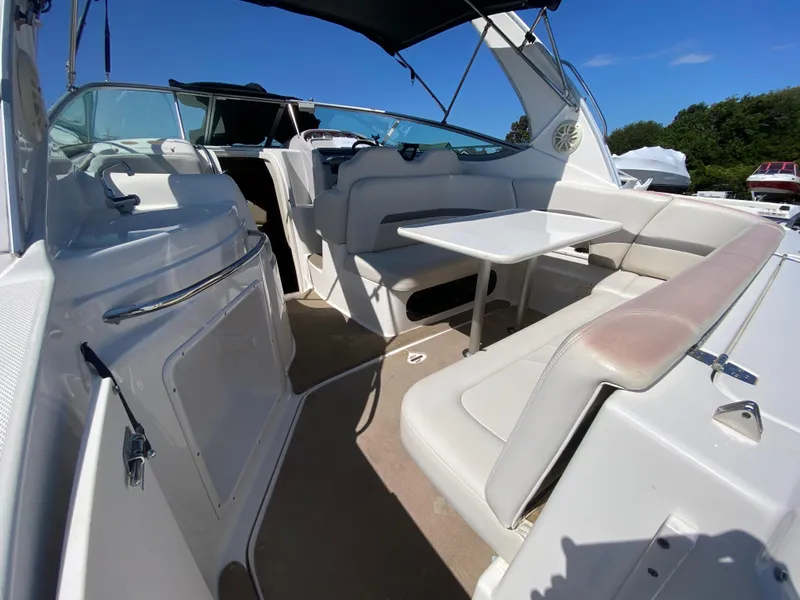 Slide: The Image of 2005 Chaparral 290 Signature boat interior with seating and table under blue sky. - 18