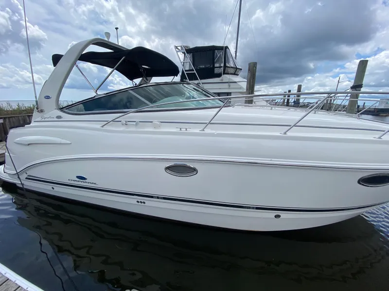 Slide: The Image of 2005 Chaparral 290 Signature boat docked at marina under cloudy sky. - 1