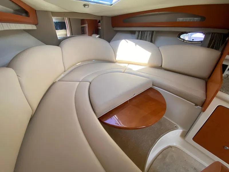 Slide: The Image of 2005 Chaparral 290 Signature cabin interior with beige seating and wooden table. - 25