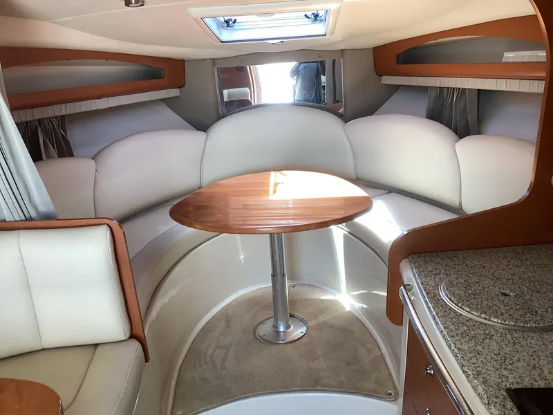 Slide: The Image of Interior of 2005 Chaparral 290 Signature boat with white seating and wooden table. - 27