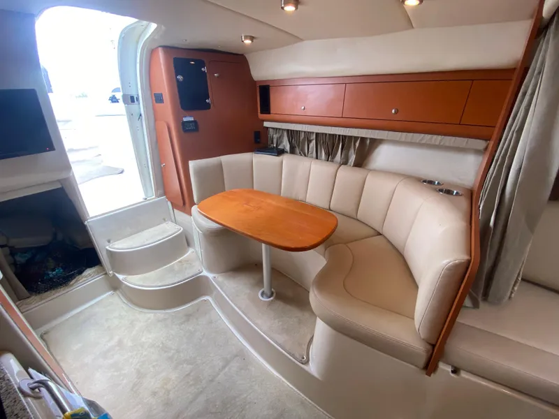 Slide: The Image of 2005 Chaparral 290 Signature cabin interior with curved seating and wooden table. - 29