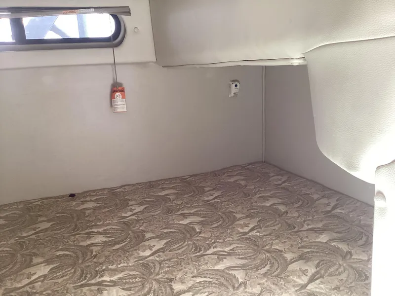 Slide: The Image of 2005 Chaparral 290 Signature cabin interior with patterned bedding and small window. - 32