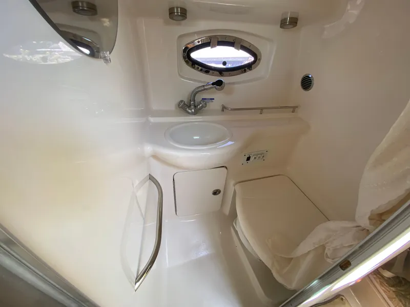 Slide: The Image of 2005 Chaparral 290 Signature boat bathroom with sink, toilet, and porthole window. - 35