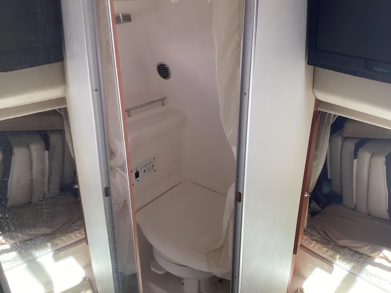 Slide: The Image of 2005 Chaparral 290 Signature boat interior bathroom with compact design and white fixtures. - 44