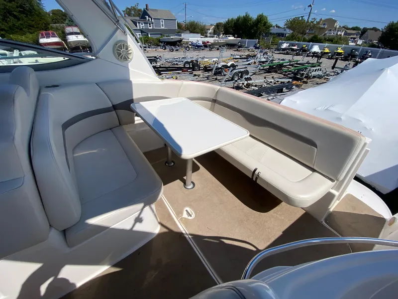 Slide: The Image of 2005 Chaparral 290 Signature boat interior with seating and table, docked in a marina. - 14