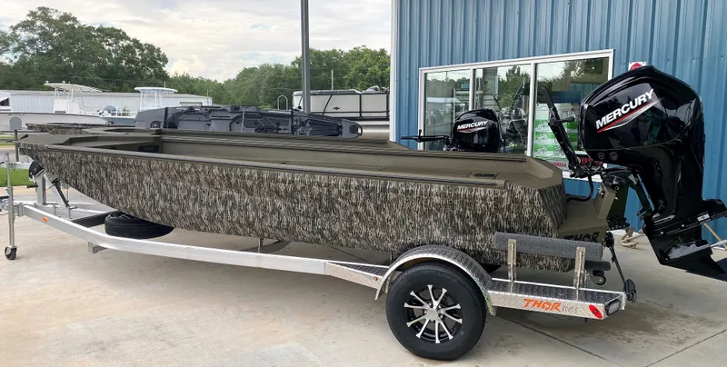 Slide: The Image of 2023 Thor 1860 boat with camouflage design and Mercury outboard motor on trailer. - 3