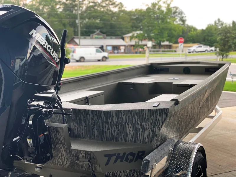 Slide: The Image of 2023 Thor 1860 boat with Mercury engine on trailer, parked outdoors. - 5