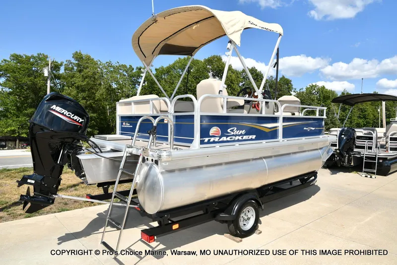 Slide: The Image of 2025 Sun Tracker Bass Buggy 16 XL Select pontoon boat with Mercury engine on trailer. - 3