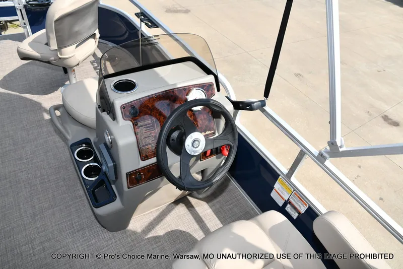 Slide: The Image of 2025 Sun Tracker Bass Buggy 16 XL Select boat interior with steering wheel and seating. - 32