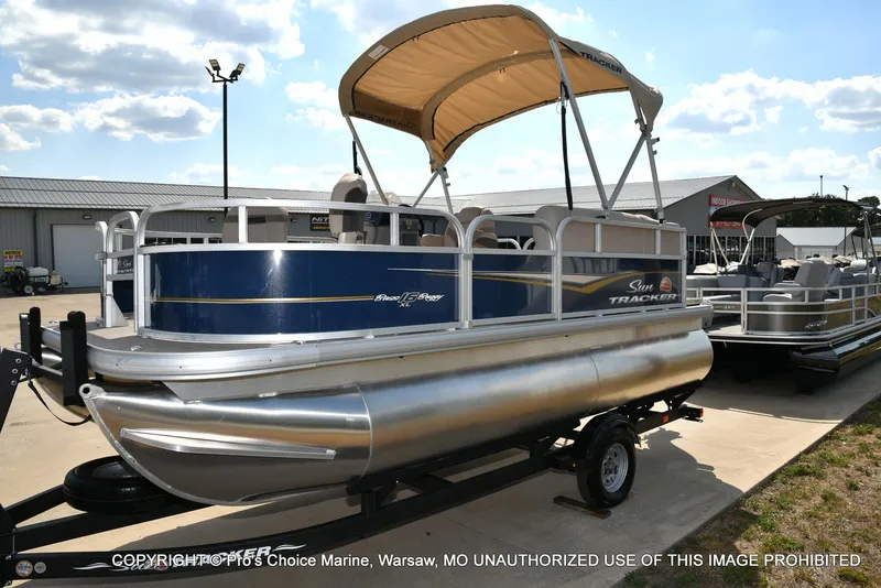Slide: The Image of 2025 Sun Tracker Bass Buggy 16 XL Select pontoon boat on trailer, outdoor display. - 44