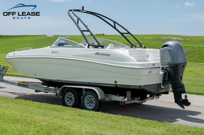 Slide: The Image of 2020 Hurricane 217 SD boat on trailer, parked on grass, clear sky background. - 8