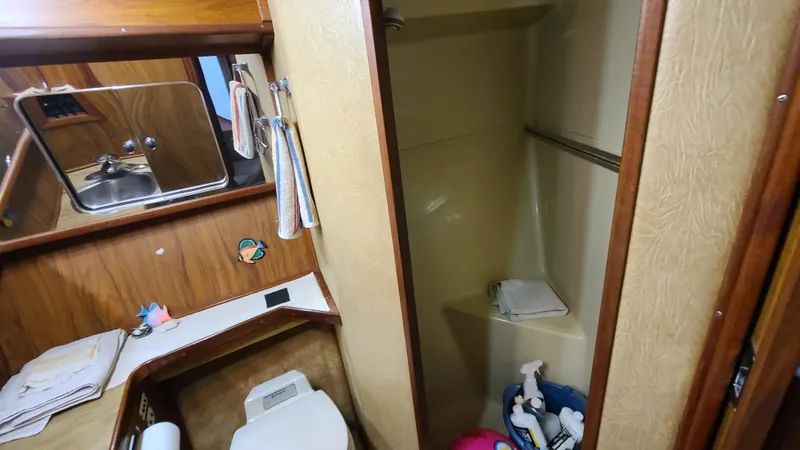Slide: The Image of 1983 Sea Ray 360 Aft Cabin bathroom with sink, toilet, and shower area. - 20
