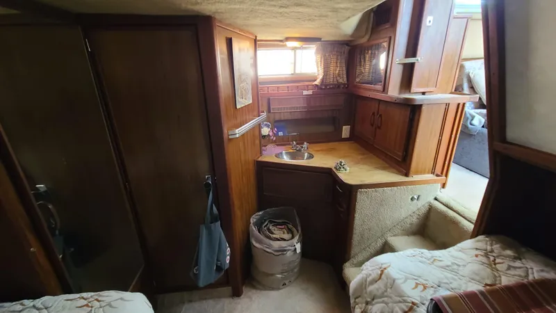 Slide: The Image of 1983 Sea Ray 360 Aft Cabin interior with wood cabinetry and cozy sleeping area. - 24