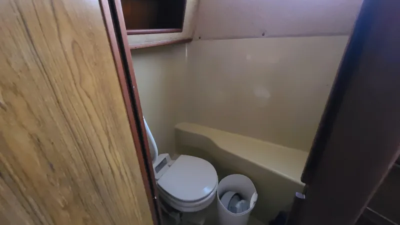 Slide: The Image of 1983 Sea Ray 360 Aft Cabin bathroom with toilet and wooden paneling. - 25
