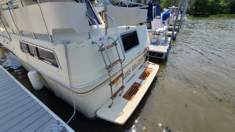 Slide: The Image of 1983 Sea Ray 360 Aft Cabin docked at marina, rear view with ladder and platform. - 3
