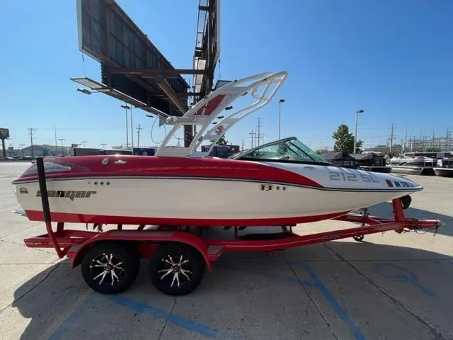 Slide: The Image of 2015 Sanger V 212 boat on a red trailer in a parking lot. - 1