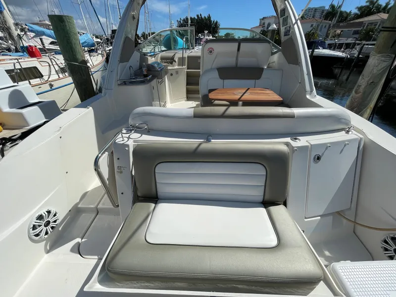 Slide: The Image of 2007 Sea Ray 310 Sundancer boat interior with seating and table, docked at marina. - 12