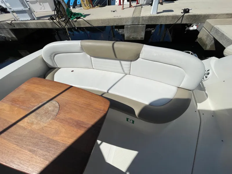 Slide: The Image of 2007 Sea Ray 310 Sundancer boat seating area with wooden table at dock. - 14