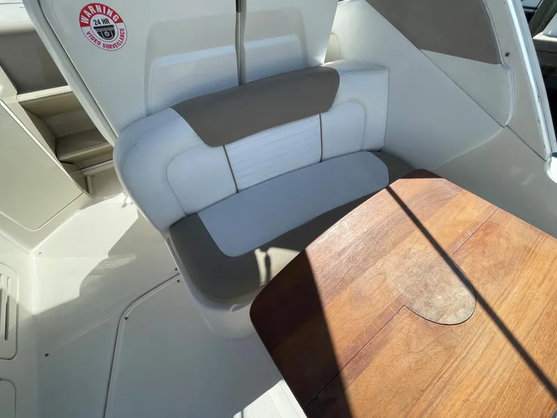 Slide: The Image of 2007 Sea Ray 310 Sundancer interior with cushioned seating and wooden table. - 15