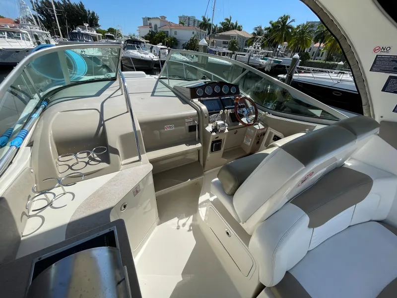 Slide: The Image of 2007 Sea Ray 310 Sundancer cockpit with helm, seating, and marina view. - 17