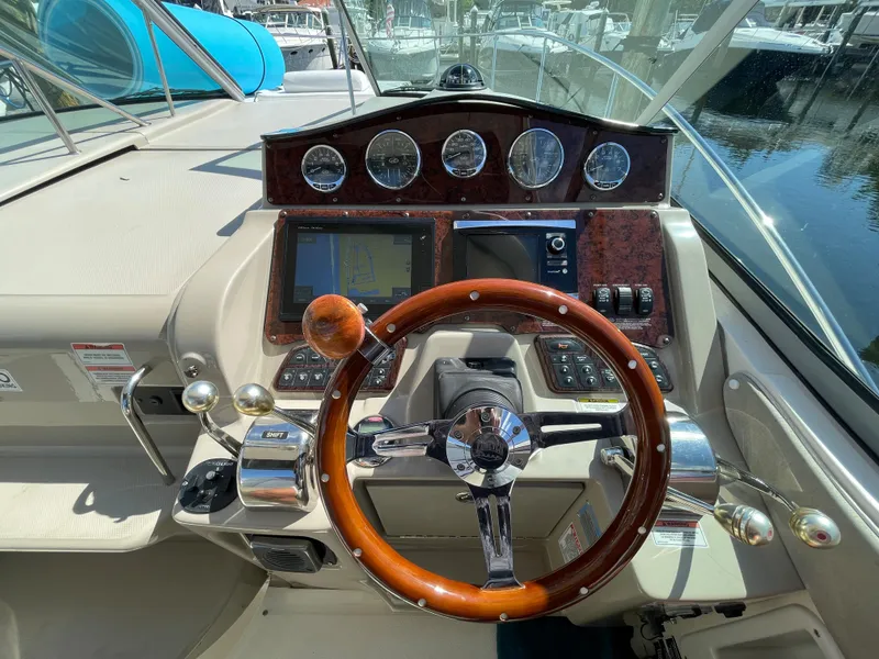 Slide: The Image of 2007 Sea Ray 310 Sundancer helm with wood steering wheel and modern controls. - 19