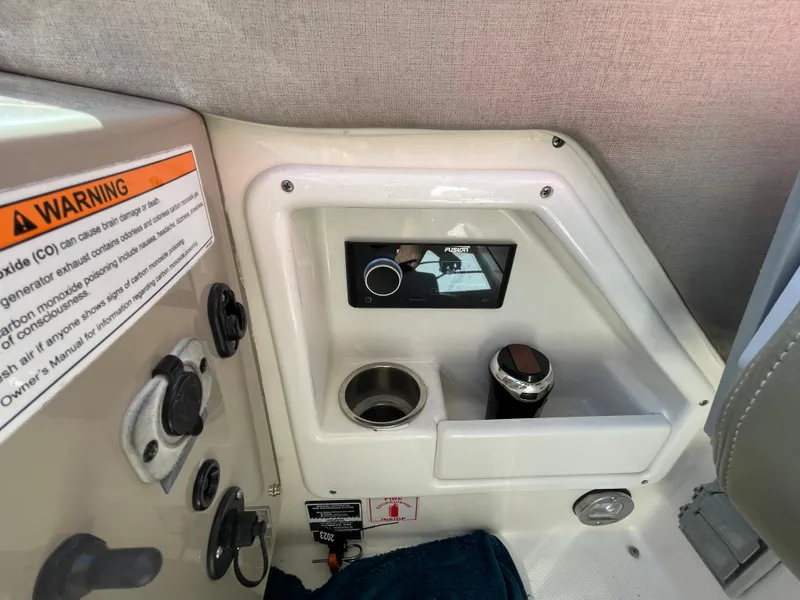 Slide: The Image of 2007 Sea Ray 310 Sundancer cockpit controls with warning label and cup holder. - 21