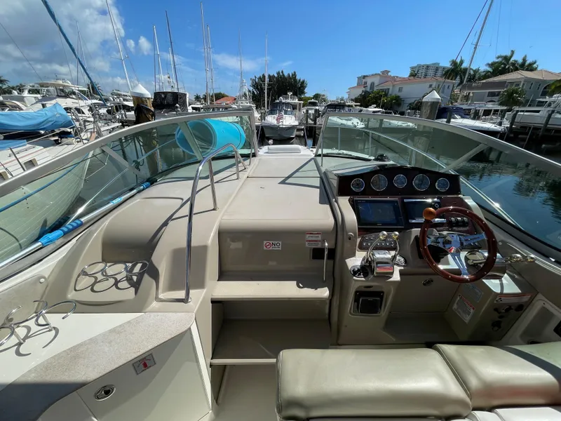 Slide: The Image of 2007 Sea Ray 310 Sundancer cockpit with steering wheel, gauges, and marina view. - 22