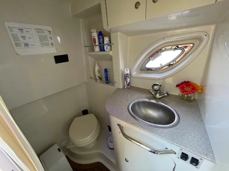 Slide: The Image of 2007 Sea Ray 310 Sundancer bathroom with sink, toilet, and storage shelves. - 25